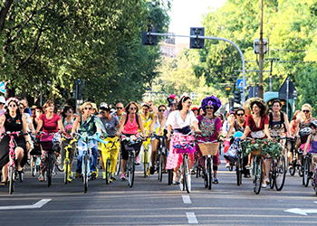 A large group of people on bikes in fancy dresses.