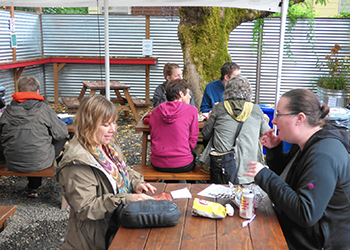 Two women eating at a food cart pod.